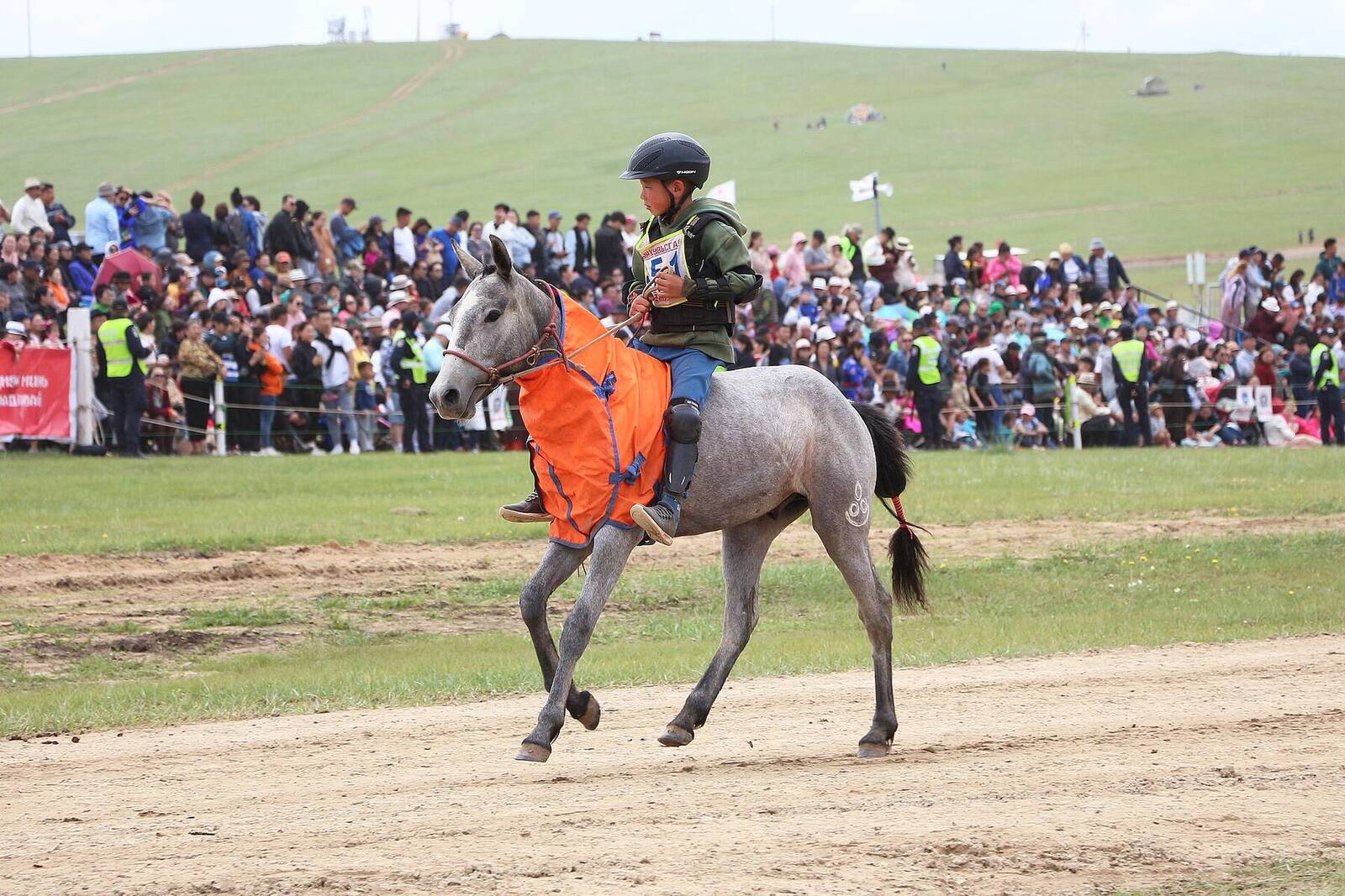 A young jockey on a grey horse at the Naadam horse race